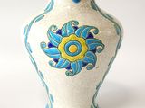 a white vase with a blue and yellow design on it