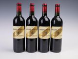 three bottles of red wine are lined up on a white surface