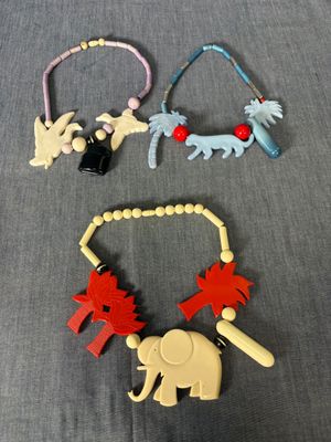 trois colliers de formes et de tailles différentes posés sur une surface grise