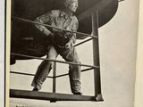 a black and white photo of a man standing on a boat