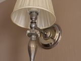 une lampe accrochée au mur à côté d'un abat-jour