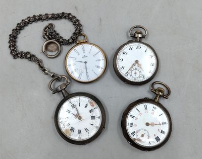 Trois montres de poche anciennes sont posées sur une table, à côté d'une chaîne