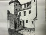 quelqu'un tient un bout de papier sur lequel est dessiné un bâtiment