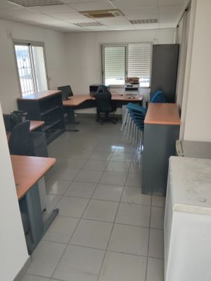 une photo d'un bureau vide avec des bureaux et des chaises