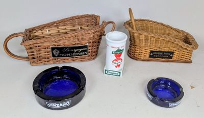 un panier en osier, un cendrier en verre bleu et un cendrier en verre bleu posé sur une table