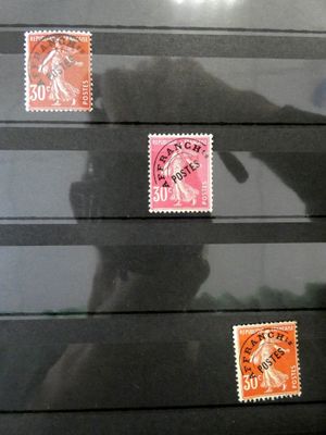 un homme debout devant un mur orné de timbres