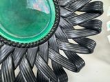 a green bowl sitting on top of a black flower