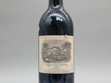 une bouteille de vin rouge posée sur une table blanche
