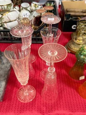 de nombreux vases en verre posés sur une table recouverte d'une nappe rouge