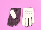 une paire de gants en cuir noir et blanc sur fond rose