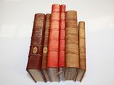five old books stacked on top of each other on a table