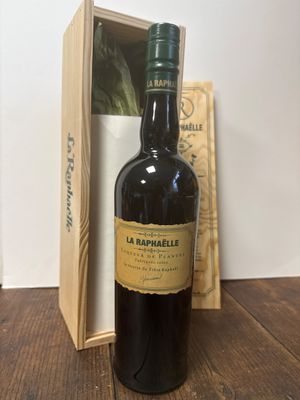une bouteille de vin posée sur une table à côté d'une boîte