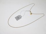 une photo d'un collier muni d'une étiquette, posé sur une surface blanche