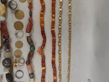 many different necklaces and bracelets laid out on a table