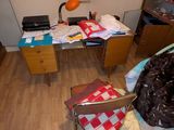 une chambre en désordre avec un bureau et une chaise à l'intérieur