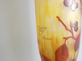 un vase avec un tableau posé sur une table
