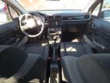 the interior of a small car with black seats and a steering wheel