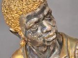 a gold statue of a man with a hat on