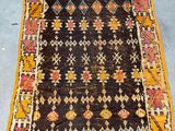 an old rug with a yellow border and a black background