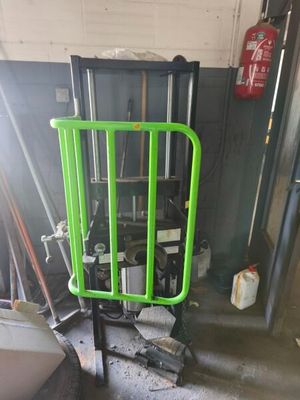 un portillon vert au milieu d'une pièce, à côté d'une borne d'incendie