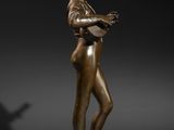 a bronze statue of a woman holding a book