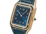 a close up of a wrist watch with a blue dial