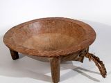 un vieux bol en bois posé sur un socle en bois