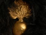 a black fur coat with a gold ball on it