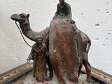statue représentant un homme à dos de chameau, sur lequel se trouvent deux autres hommes
