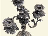 a silver candelab with flowers on it on a white background