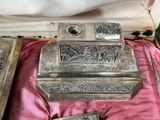 a silver box that has some silver items inside of it
