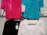 three different colored shirts hanging on a rack in a store
