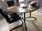 a desk with a laptop and a chair in a room