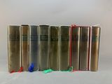 four books are lined up in a row on a white surface