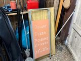 a sign on the ground next to a door and a chair
