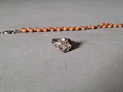 un gros plan d'un collier en perles sur lequel est accrochée une bague