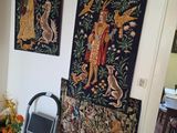 tapestry hanging on the wall of a living room with a chair and a table