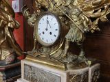 une horloge posée sur une table à côté d'un miroir