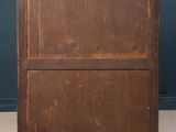 an old wooden chest of drawers against a dark blue wall