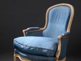 un fauteuil rembourré bleu avec une structure en bois et une assise rembourrée bleue