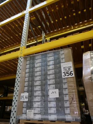 Les cartons sont empilés sur des palettes dans un vaste entrepôt.