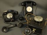several old fashioned telephones are sitting on a gray surface