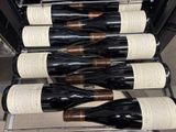 several bottles of wine are lined up on a rack in a wine cellar