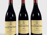 three bottles of red wine sitting next to each other on a white surface