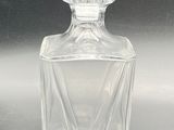 a clear glass bottle with a diamond shape on it