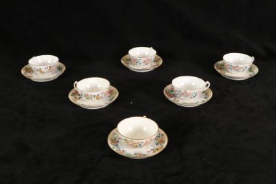 six tasses et soucoupes sont disposées en cercle sur un fond noir