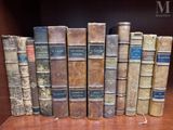 several old books are lined up in a row on a shelf