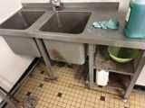 a dirty sink in a dirty kitchen with a mop on the floor
