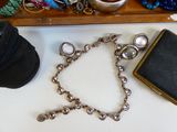 un bracelet en argent et un sac à main noir posés sur une table