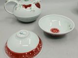 three pieces of porcelain teapots and a bowl on a table